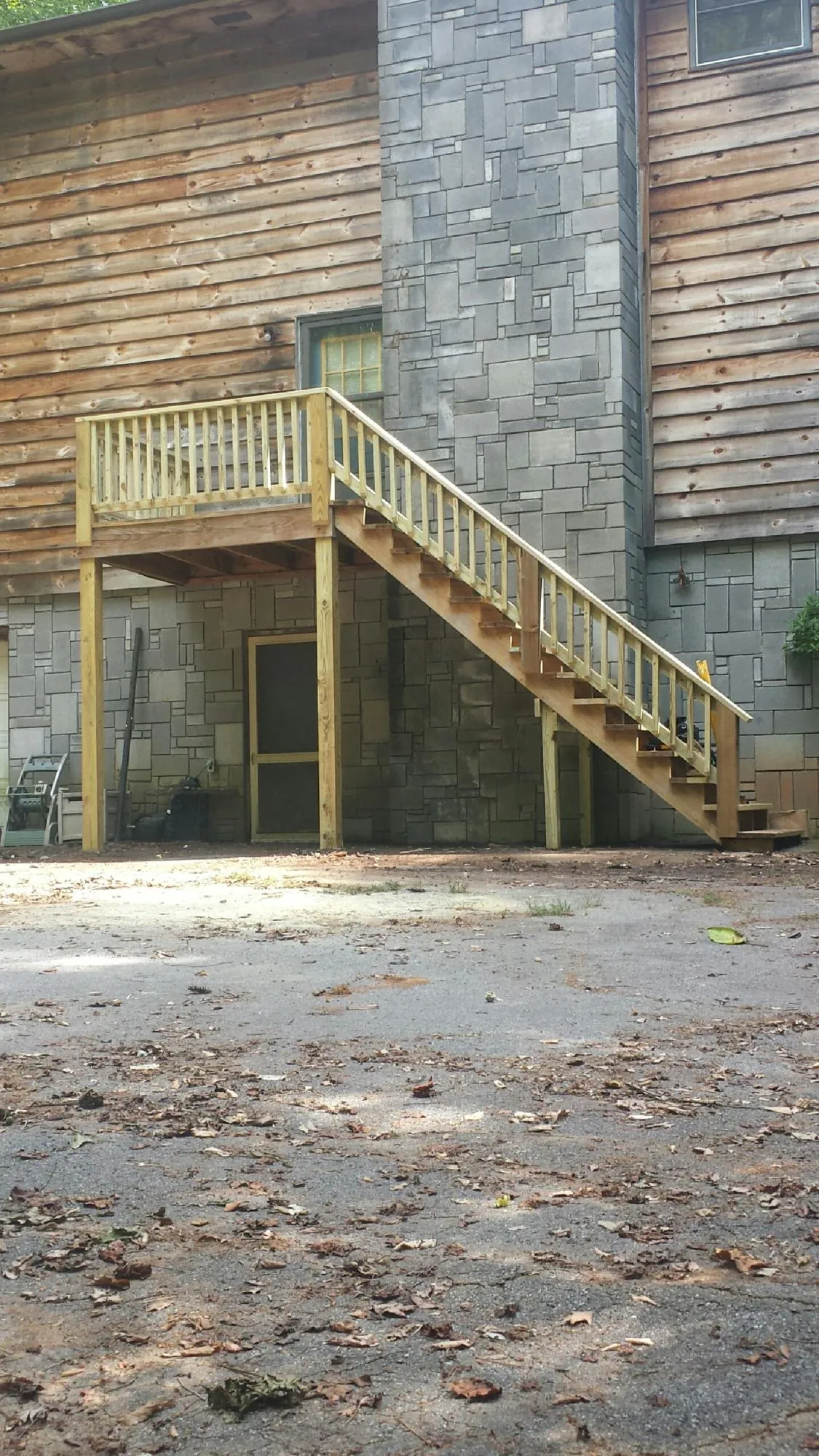 New pressure treated deck and stair landing on a log home in South Haven